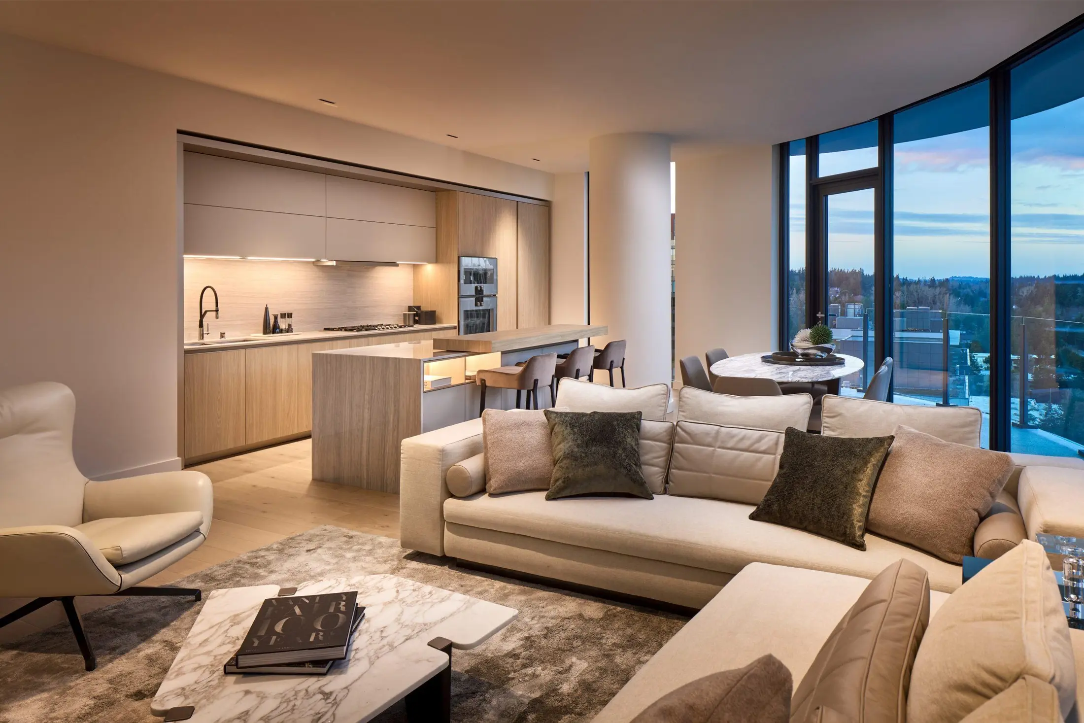 Sala integrada com sofá e vista ao entardecer em apartamento contemporâneo.